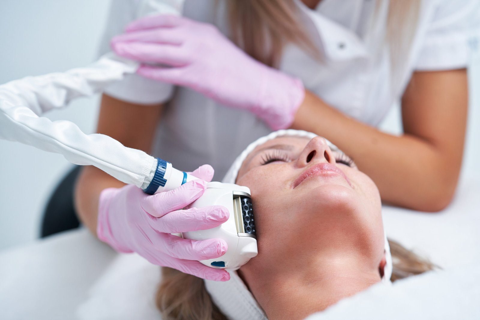 "Woman receiving Sculptra facial injection treatment from a professional wearing gloves.
